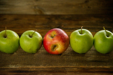 Fresh red apples with green leaves on wooden table. On wooden background. Free space for text . Top view