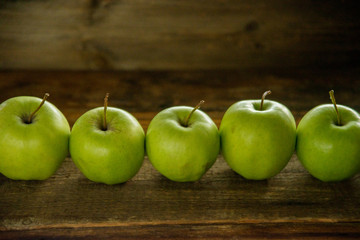 Fresh red apples with green leaves on wooden table. On wooden background. Free space for text . Top view