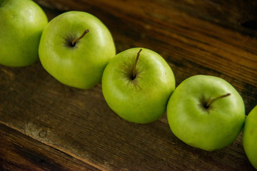 Fresh red apples with green leaves on wooden table. On wooden background. Free space for text . Top view