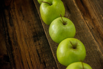 Fresh red apples with green leaves on wooden table. On wooden background. Free space for text . Top view