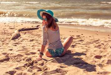 The sexy girl on the beach in a hat.