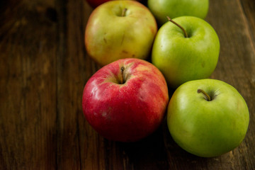Fresh red apples with green leaves on wooden table. On wooden background. Free space for text . Top view