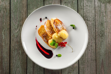 Delicious toasts with fruit jam and custard on a plate. Healthy European breakfast on a rustic wooden table. Top view.