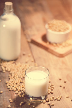 Soy milk or soya milk and soy beans on wooden table.