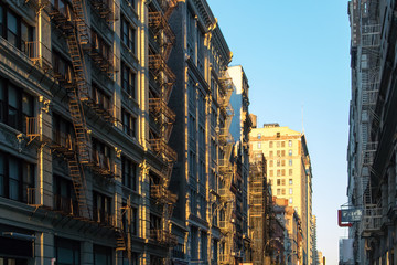 Warm light of sunset shining down a block of buildings in New York City