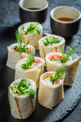 Closeup of tortilla with vegetables and cheese on black rock