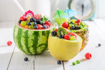Tuinposter Fruits salad in melon and pineapple with berry fruits © shaiith