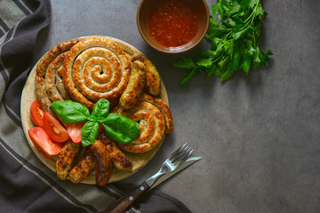 Assorted freshly roasted spicy sausages on a round board