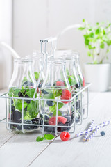 Fresh water in bottle with berries on white table