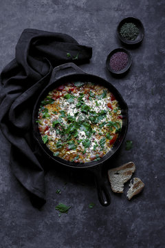 Shakshuka a dish of eggs poached in a sauce of tomatoes, chili peppers, and onions, spiced with cumin.