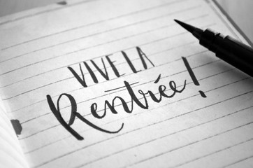 "VIVE LA RENTREE!" lettrage &agrave; la main sur cahier