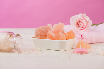 Spa settings with roses. Various items used in spa treatments on white wooden background.