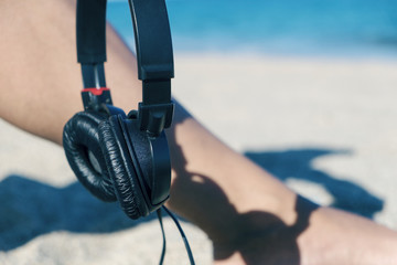 young man with headphones on the beach