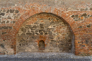 Brick and stone medieval wall with an arch