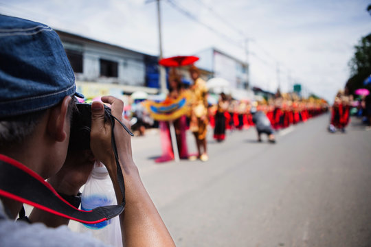 Tourists are taking picture of Lent Festival parade in Thailand.