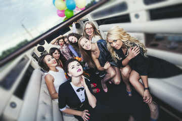 Young beautiful happy women celebrate bachelorette party in a convertible limousine - obrazy, fototapety, plakaty