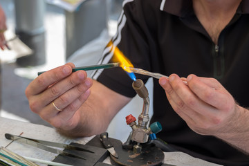 Hamds of lampwork master make glass figure