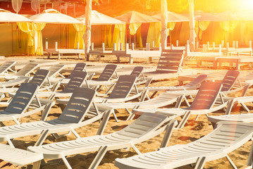 Beach sun loungers stand on the sand, relax.
