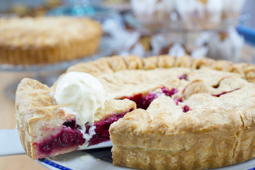 Homemade traditional sweet raspberry tart pie with ice cream on wooden table background.