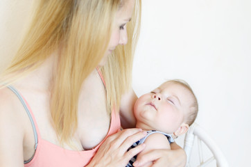 Young happy mother with sleeping infant boy