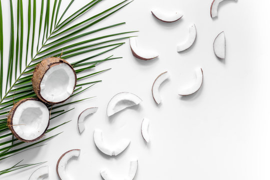 Appetizing cocount and palm branch on white background top view