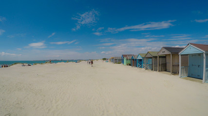 Traditional beach huts on fine golden sand at West Wittering Beach West Sussex England UK 