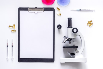 Medical tests. Work table of doctor witn microscope, Petri dish, syringe on white background top view mockup