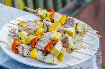 Tasty skewers of fresh fish with vegetables and apples on a wooden shish kebab - 163825997