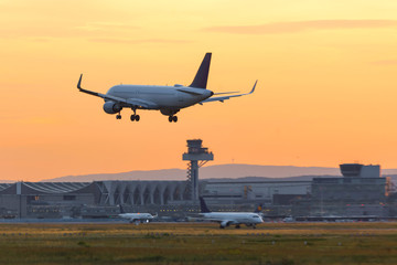 Fototapeta na wymiar airplane landing on an airport in the evening