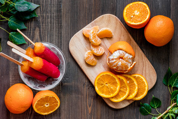 Oranges, mandarins and citrus ice cream on wooden table background top view