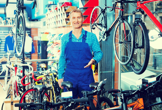 man seller standing in bike store.