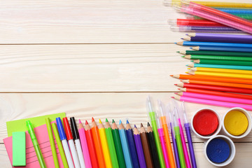 Obraz premium school and office supplies. school background. colored pencils, pen, pains, paper for school and student education on white wooden background. top view with copy space