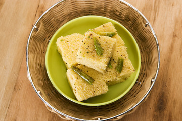 Dhokla topped with sesame seeds and green chillie