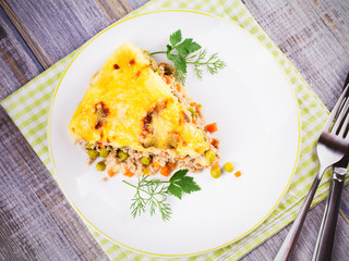 Traditional shepherd pie. Meat, potato, cheese, carrot, onion and green peas casserole. View from above, top studio shot