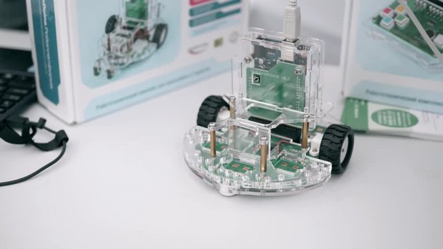 Close-up of little handmade toy car. Children auto made from construction and electronic components. Hobby, leisure, diy, robotics concept