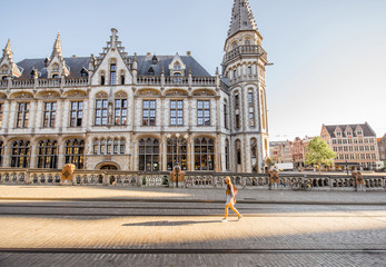 Obraz premium Stret view on the Post office building with woman walking during the morning in Gent city, Belgium