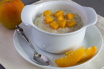 Oatmeal with milk and apricot in the white plate