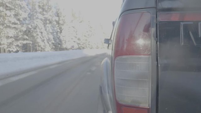 Headlight closeup on snowy roads. The car rides on a snow-covered road. Timelapse