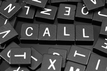 Black letter tiles spelling the word "call" on a reflective background