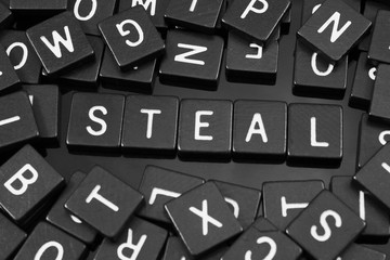Black letter tiles spelling the word "steal" on a reflective background