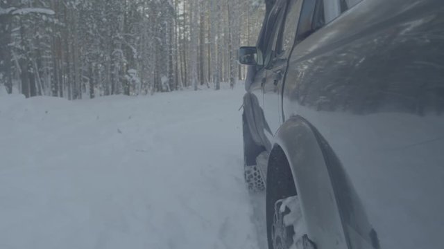 Jeep rides on the snow in the forest closeup.