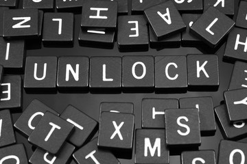 Black letter tiles spelling the word "unlock" on a reflective background