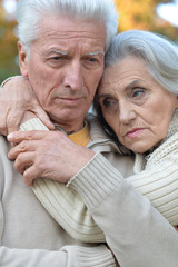 Sad elderly couple in the park