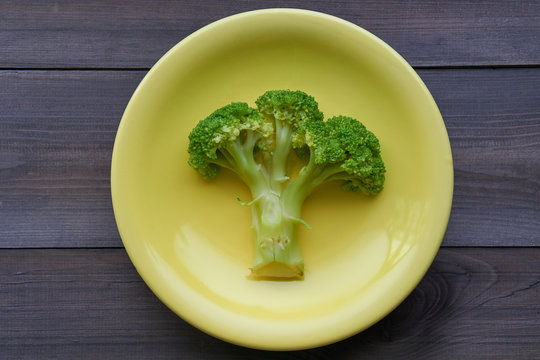 boiled broccoli on a yellow plate