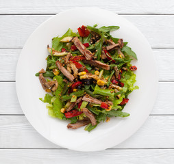 Multicolored vegetable salad with grilled meat. Healthy food, dietary meal, lunch dish concept. White wooden planks background.