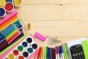 school and office supplies. school background. colored pencils, pen, pains, paper for  school and student education on wooden background. top view with copy space