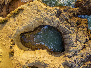 Algarve, Portugal: aerial UAV photo of rocks in the coast of Albufeira at sunrise
