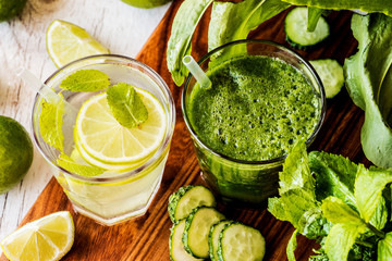 green smoothie and detox water with lime, mint and ice on wooden background. detox diet. Close-up