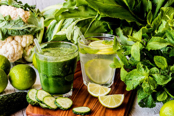 green smoothie and detox water with lime, mint and ice on wooden background. detox diet.