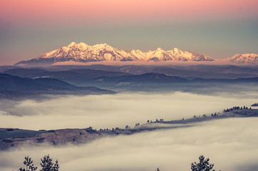 panorama over misty Spisz highland to snowy Tatra mountains in the morning, Poland and Slovakia landscape